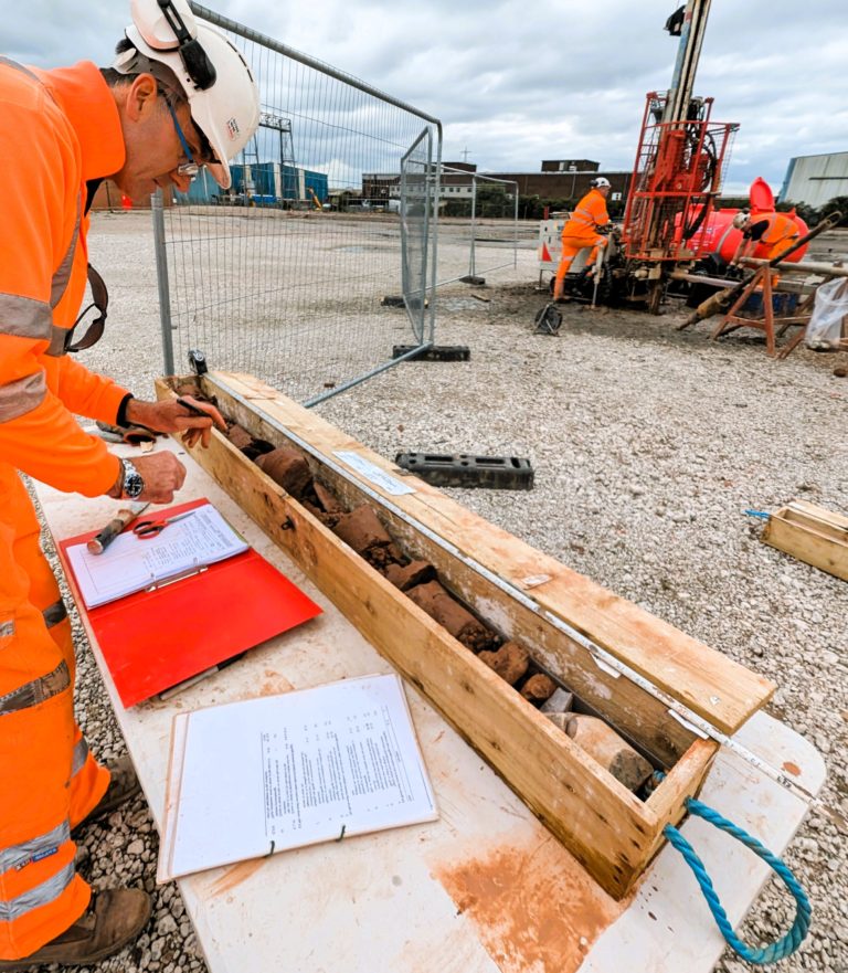 CJ Associates worker dressed in hi-vis personal protective clothing, completing core logging.